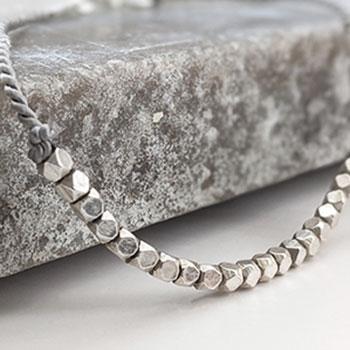 Silver beaded bracelet on silk cord
